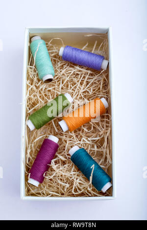 Picture of multicolored sewing thread in the box. Isolated on the white background. Stock Photo