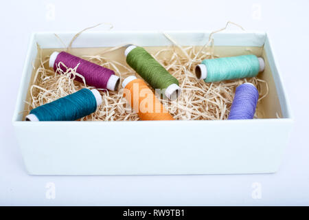 Colorful sewing thread in the box. Isolated on the white background. Stock Photo