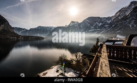 Slow exposure photo captures the dawn sunrise & reflections during golden hour over Hallstatt lake in Austria Stock Photo
