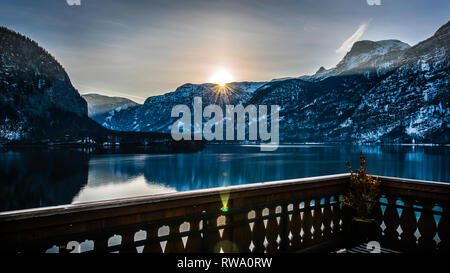 Slow exposure photo captures the dawn sunrise & reflections during golden hour over Hallstatt lake in Austria Stock Photo