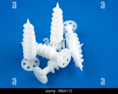 Special dowels for fixing light objects in styrofoam insulation, on blue background Stock Photo