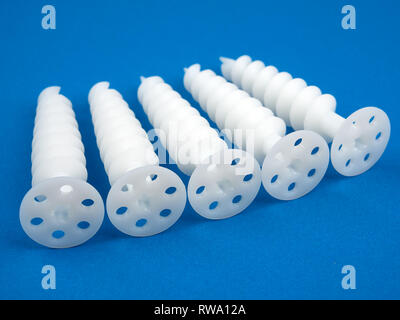 Special dowels for fixing light objects in styrofoam insulation, on blue background Stock Photo