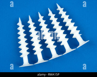 Special dowels for fixing light objects in styrofoam insulation, on blue background Stock Photo