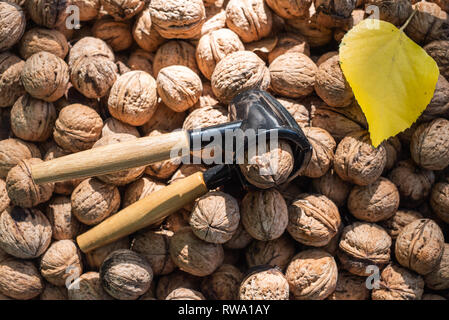 Nutcracker and lot of walnuts on table Stock Photo