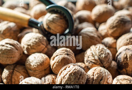 Nutcracker and lot of walnuts on table Stock Photo
