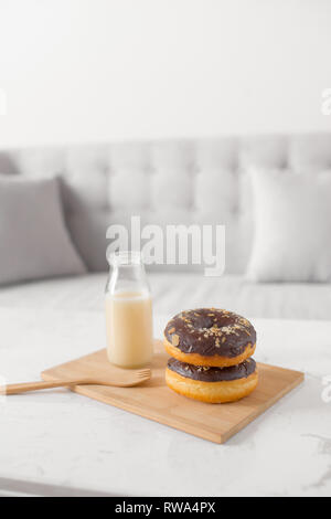 Chocolate donut. Morning breakfast with milk on table in living room at home. Stock Photo