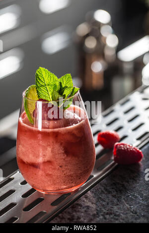 Cocktail drink frozen raspberries  daiquiri at barcounter in night club or restaurant. Stock Photo