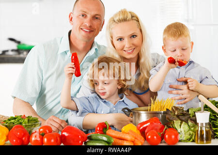 Happy family is preparing a healthy dinner in the kitchen. Stock Photo