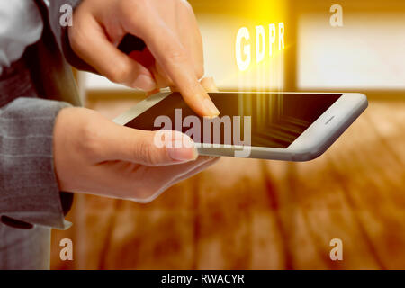 Business woman touching the mobile phone screen and display GDPR text with office room background. Cyber security and privacy. General Data Protection Stock Photo