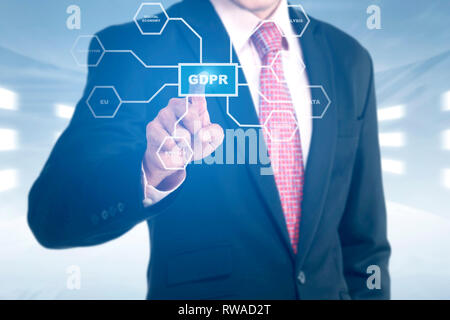 Hand of businessman pointing at shield with keys icon and GDPR text button with protection structure on virtual screen. Cyber security and privacy. Ge Stock Photo