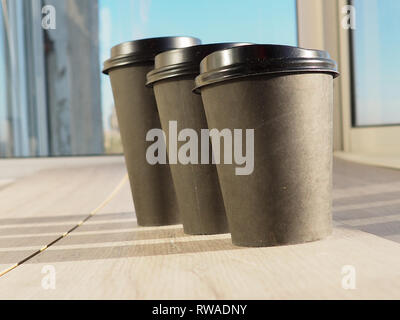 Cups of coffee different sizes on cafe table near window. Stock Photo