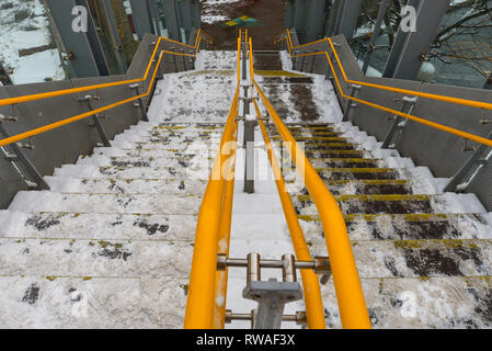 London DLR train station steps covered in snow. Rush hour danger. Dangerous slippery stairs. Ice on the pavement surface, risk of injuries. Stock Photo