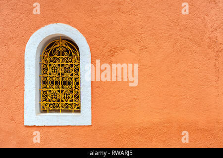 Window with stylish metal grille on colour wall. Marrakesh, Morocco, North Africa