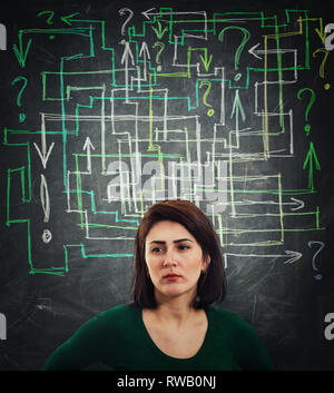 Puzzled and thoughtful young woman having a lot of questions like a mess arrows coming out of head. Anxiety stress and headache feeling. Solving a maz Stock Photo