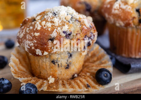 Closeup of a blueberry muffin and berries with muffins in background Stock Photo