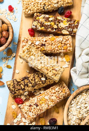 Granola bar with nuts, fruits and berries on blue. Stock Photo