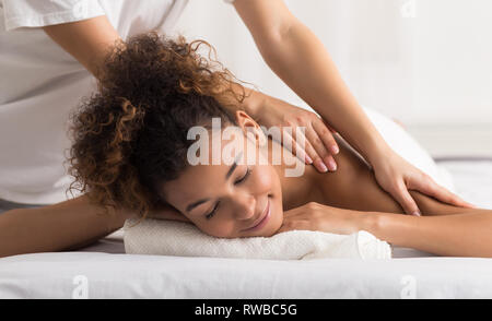 Woman enjoying shoulder massage in spa center Stock Photo