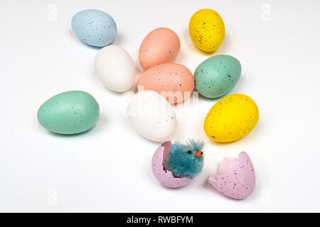 colored easter eggs with little chicks on a white surface Stock Photo