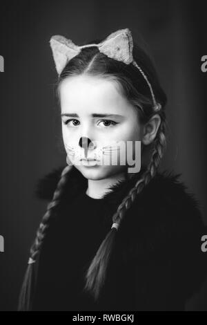Cute little girl dressed and maked-up like a cat, childhood Stock Photo