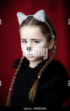 Cute little girl dressed and maked-up like a cat, childhood Stock Photo