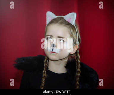 Cute little girl dressed and maked-up like a cat, childhood Stock Photo