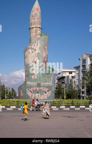 Ethiopians walk past the Sidamo Monument in Hawassa (Awasa) in Ethiopia. It represents the Sidama people's heritage Stock Photo