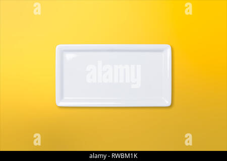 Empty white cornered plate on yellow orange gradient background, view directly from above Stock Photo