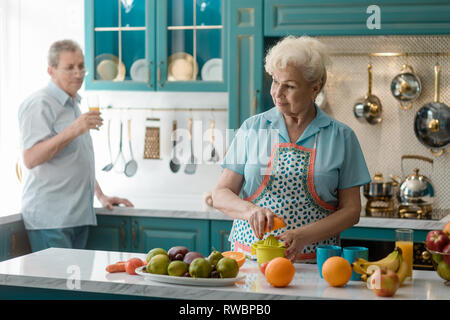 Old woman squeezing an orange Stock Photo
