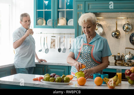Grandmother squeezing an orange Stock Photo