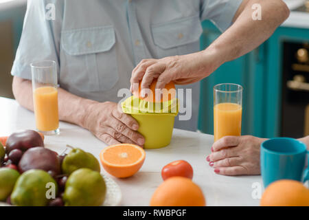 Old man squeezing an orange Stock Photo