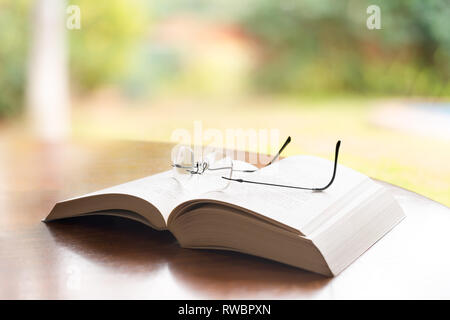 Reading glasses on top of a book Stock Photo