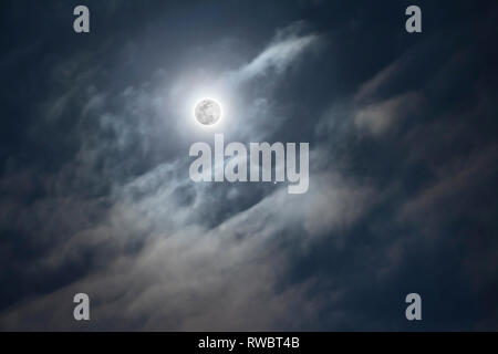 A full Moon on cloudy sky background. Jupiter planet with moons. Telescopic astrophotography. Astronimical event Stock Photo