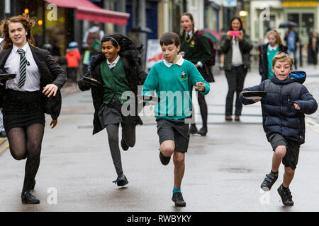 Chippenham, Wiltshire, UK. 5th March, 2019. Heavy rain this afternoon failed to dampen the spirits of local children who are pictured taking part in the annual pancake race on Chippenham high street.  Credit: Lynchpics/Alamy Live News Stock Photo