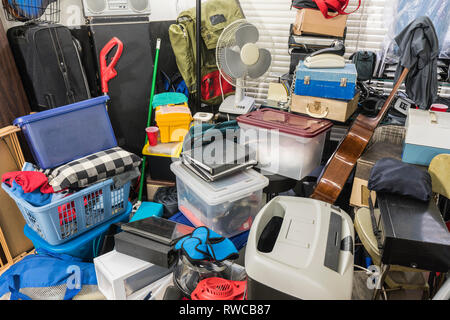 Hoarder home packed with stored boxes, vintage electronics, files, business equipment and household items. Stock Photo