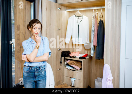 Closet woman can't decide, confused by outfits or needing to organize  closet with too many clothing. Funny girl indecision clothes choices,  spring Stock Photo - Alamy