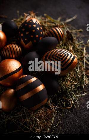 Black and gold eggs in nest. Easter holiday concept Stock Photo