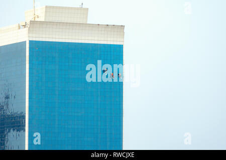 Workers washing windows in a skyscraper in Dubai. Stock Photo