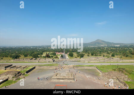 View from the Pyramid of the Sun showing the entrance to the archaeological site with tourists walking on Avenue of the Dead at Teotihuacan in Mexico Stock Photo