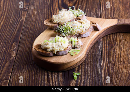 Fish pate, minced herring fillet with apple and egg on toasted rye bread, homemade traditional Jewish cuisine dish forshmak, snack or appetizer on rus Stock Photo