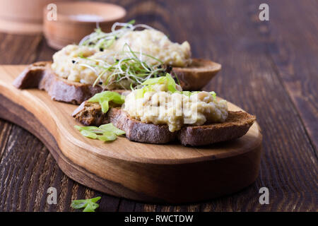 Fish pate, minced herring fillet with apple and egg on toasted rye bread, homemade traditional Jewish cuisine dish forshmak, snack or appetizer on rus Stock Photo