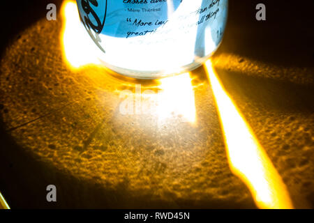 Blue Kombucha Glass Bottle Surrounded By Reflections of the Sun. Stock Photo