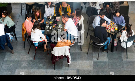 A young lady learning to smoke a water pipe (hookah) at a cafe bar in Seville, Spain Stock Photo