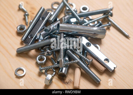 Slide of bolts and nuts lying on a white table Stock Photo