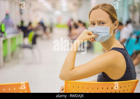 Young woman sitting in hospital waiting for a doctor's appointment. Patients In Doctors Waiting Room Stock Photo