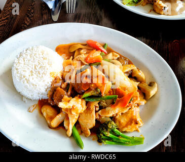 Thai Food with rice, vegtables, broccoli, red curry sauce, paprika and chicken meat. Stock Photo