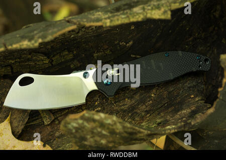 Knife chopper. Folding butcher knife. Pocket knife in the wood. Knife. Stock Photo