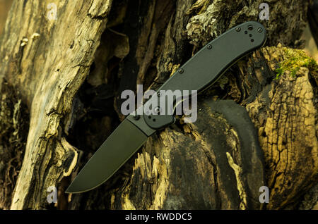 Black knife with a plastic handle. Knife with a black blade. Front view. Stock Photo