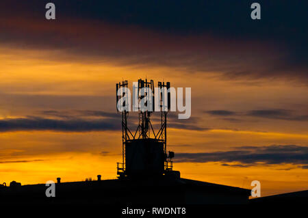 cell site on the roof of a building in silhouette Stock Photo