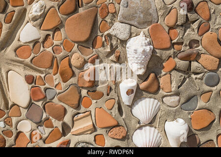 Concept of ancient culture Close up photo of broken colored stones and seashell with mosaic background .Pattern of shells in concrete as build Stock Photo