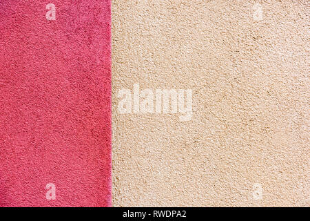 The plaster of a house facade in pink and cream colors in daylight Stock Photo
